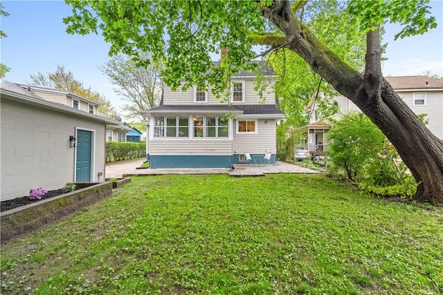 back of property with a yard and a patio