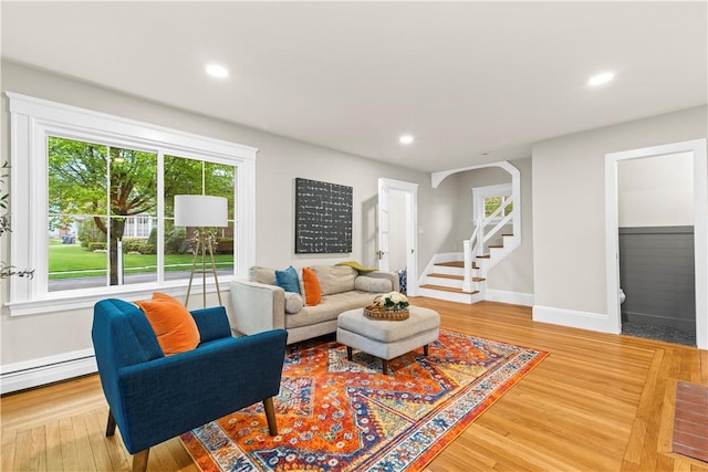 living area with recessed lighting, a wealth of natural light, and a baseboard heating unit