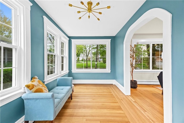 sitting room featuring baseboards, a wealth of natural light, baseboard heating, and wood finished floors