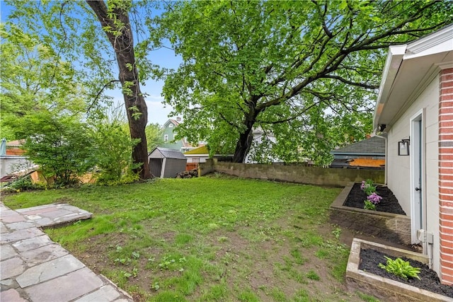 view of yard featuring an outbuilding, a shed, and a fenced backyard