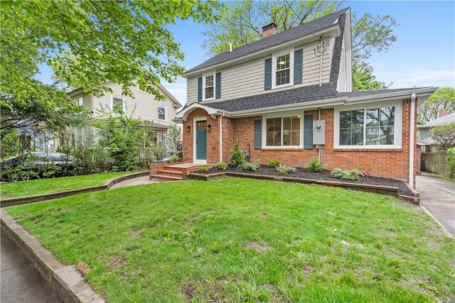 traditional-style house with fence, brick siding, a front lawn, a chimney, and a shingled roof
