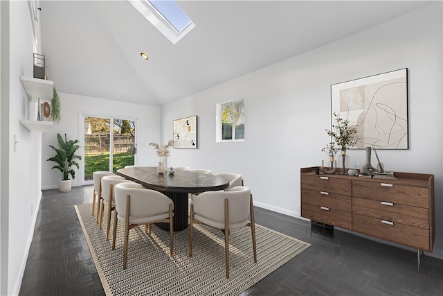 dining space featuring baseboards, high vaulted ceiling, and a skylight