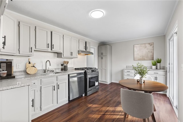 kitchen featuring crown molding, dark wood-style flooring, a sink, stainless steel appliances, and under cabinet range hood