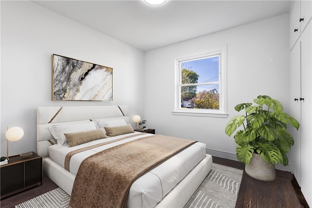 bedroom with baseboards and wood finished floors