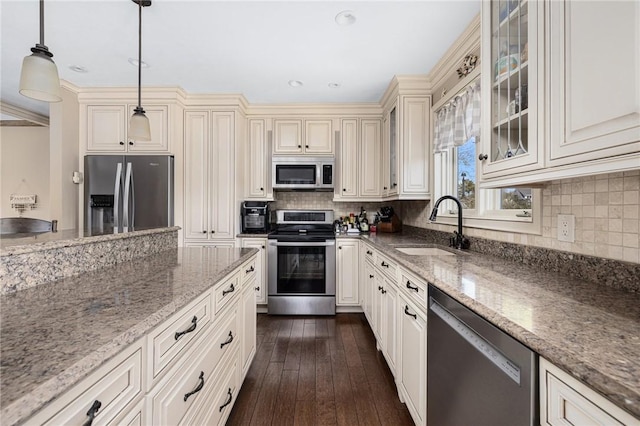 11 Renfrew Ave, Middletown, RI 02842 - kitchen featuring stainless steel appliances, cream cabinetry, a sink, light stone counters, and pendant lighting