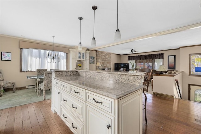 11 Renfrew Ave, Middletown, RI 02842 - kitchen featuring ornamental molding, hardwood / wood-style floors, a baseboard radiator, a chandelier, and light stone counters