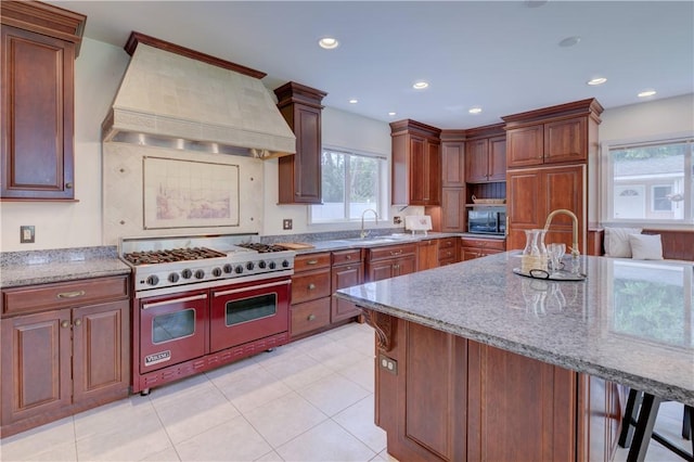 23 Pine Top Rd, Barrington, RI 02806 - kitchen with double oven range, custom exhaust hood, black microwave, light stone countertops, and light tile patterned flooring