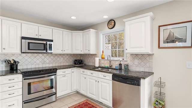 kitchen featuring a sink, stainless steel appliances, white cabinetry, and light tile patterned floors