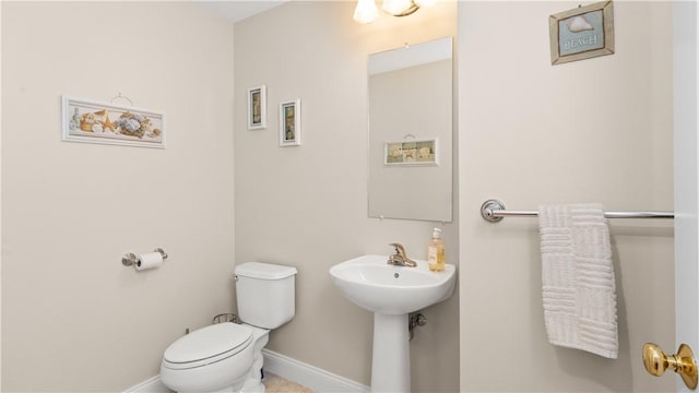 bathroom with toilet and baseboards
