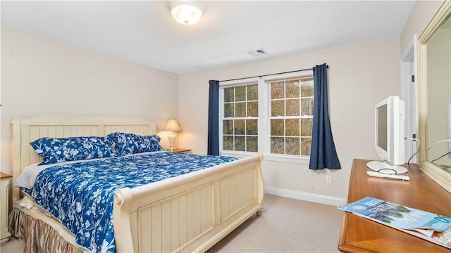 bedroom featuring baseboards, light carpet, and visible vents