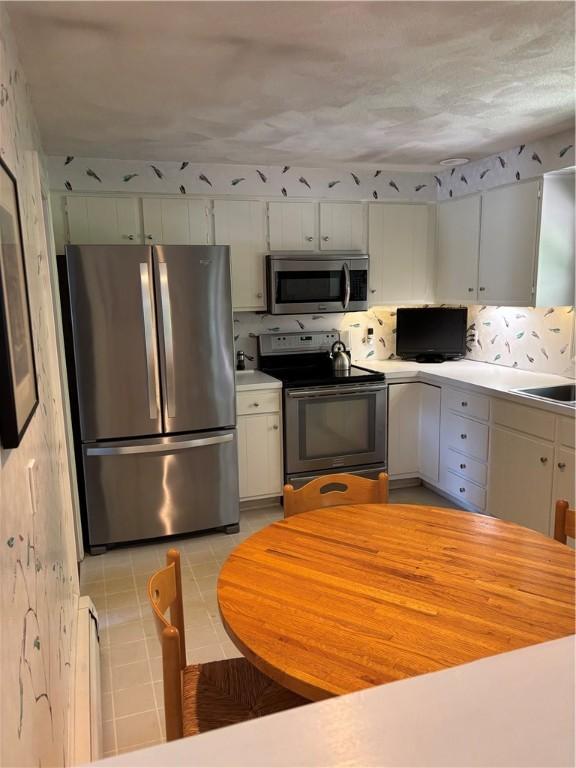 kitchen featuring a sink, decorative backsplash, appliances with stainless steel finishes, and light countertops