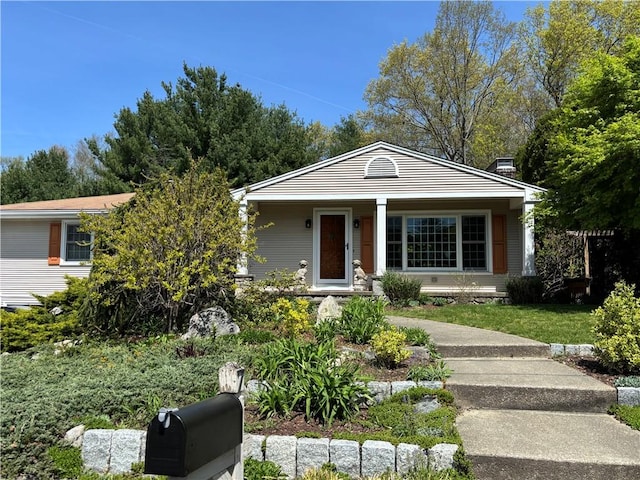 view of front facade featuring covered porch and a chimney