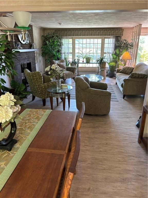 living area with a brick fireplace and wood finished floors