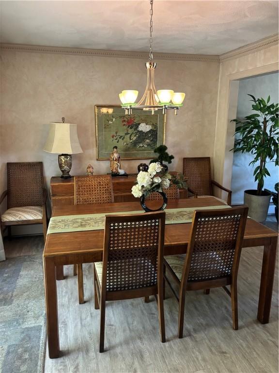 dining space with an inviting chandelier and wood finished floors