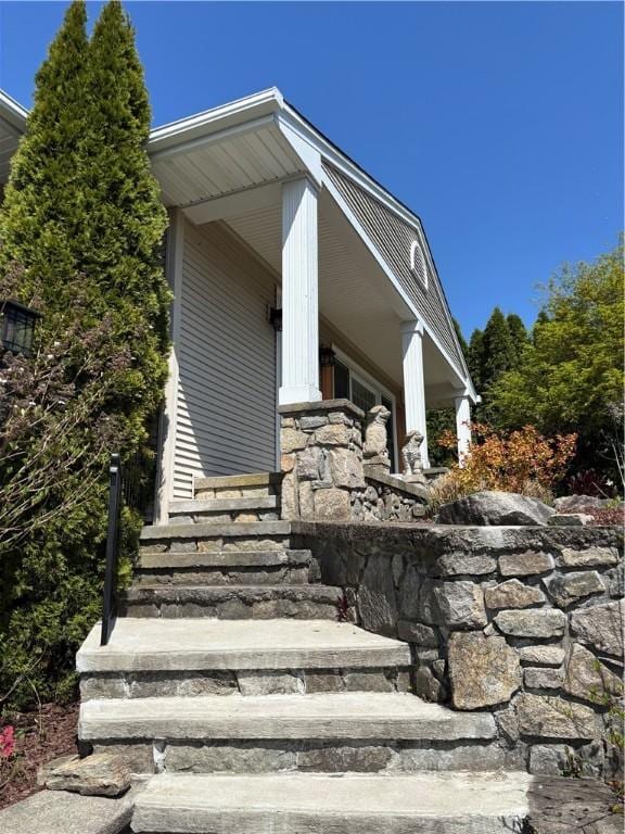 exterior space featuring a porch and stone siding