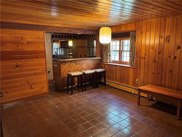 interior space featuring dark tile patterned floors, wood walls, hanging light fixtures, and wood ceiling