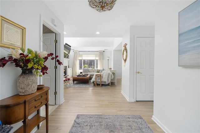 corridor with recessed lighting, baseboards, a chandelier, and light wood-type flooring