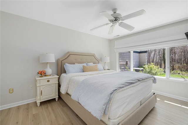 bedroom with baseboards, light wood-style flooring, and ceiling fan