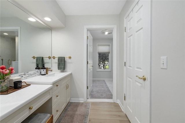 full bathroom with vanity, wood finished floors, baseboards, recessed lighting, and a shower with shower door