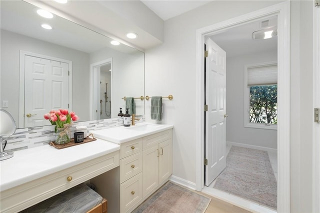 bathroom with vanity, baseboards, and recessed lighting