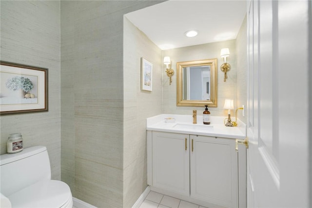 half bathroom with toilet, tile patterned floors, and vanity