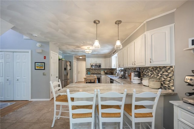 545 Central St, Burrillville, RI 02839 - kitchen featuring stainless steel appliances, a sink, a peninsula, decorative backsplash, and white cabinetry