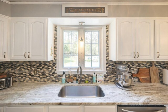 545 Central St, Burrillville, RI 02839 - kitchen with a sink, stainless steel dishwasher, white cabinets, decorative backsplash, and ornamental molding