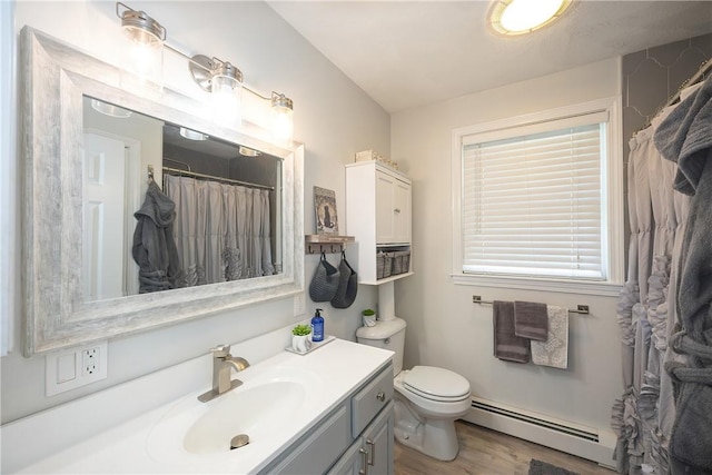 545 Central St, Burrillville, RI 02839 - full bath with a baseboard heating unit, wood finished floors, vanity, toilet, and curtained shower