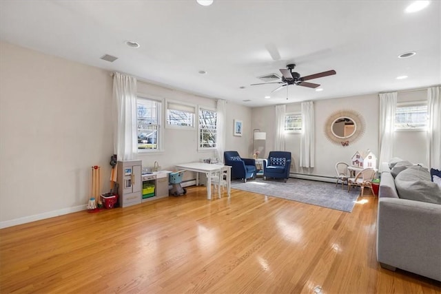 living area with ceiling fan, visible vents, a baseboard radiator, recessed lighting, and light wood-style flooring
