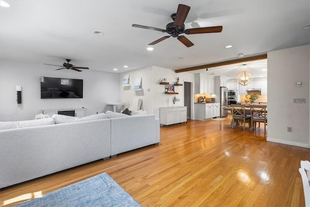 living room featuring recessed lighting, beam ceiling, ceiling fan with notable chandelier, and light wood-type flooring