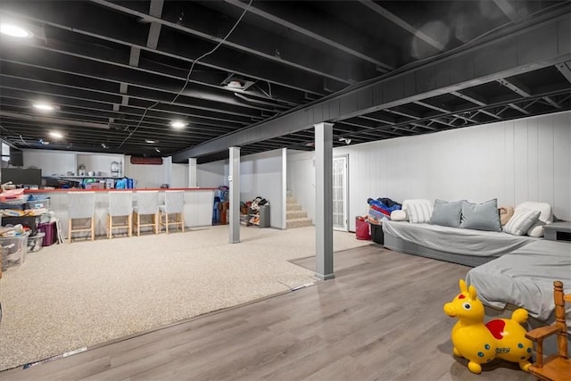 finished basement featuring wood finished floors and stairway