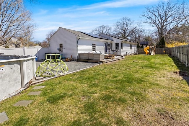 back of house featuring outdoor lounge area, a fenced backyard, a playground, a patio area, and a lawn