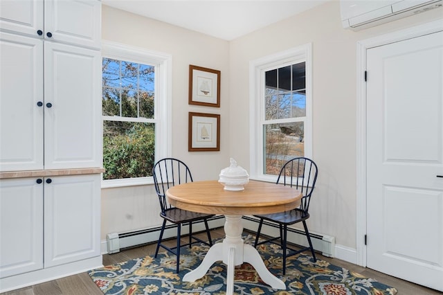 dining area with baseboards, plenty of natural light, a wall mounted AC, and wood finished floors
