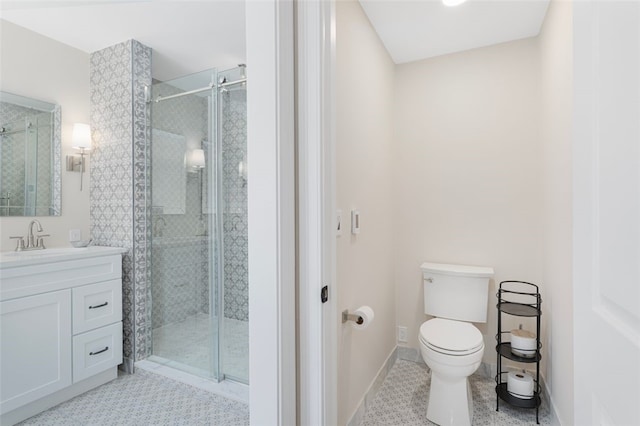 full bathroom with vanity, baseboards, a stall shower, and toilet
