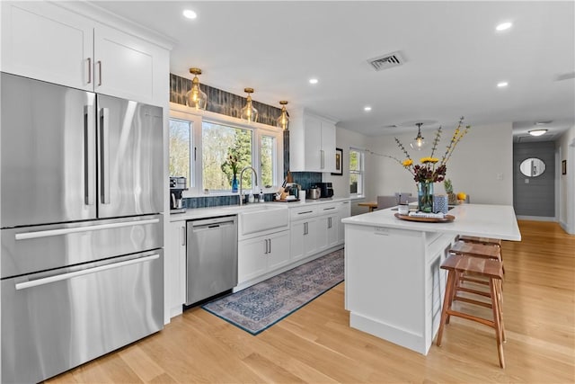 386 Stone Church Rd, Tiverton, RI 02878 - kitchen with stainless steel appliances, a sink, light countertops, light wood-style flooring, and recessed lighting