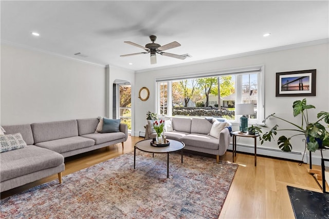 386 Stone Church Rd, Tiverton, RI 02878 - living area featuring arched walkways, wood finished floors, crown molding, ceiling fan, and a baseboard radiator