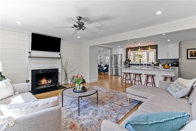 386 Stone Church Rd, Tiverton, RI 02878 - living area featuring light wood-type flooring, a fireplace, recessed lighting, a ceiling fan, and crown molding