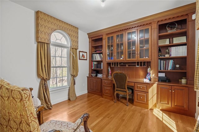 office space featuring a healthy amount of sunlight, light wood-style flooring, and built in study area