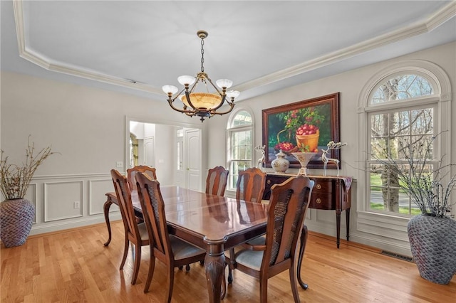 dining room with crown molding, plenty of natural light, a tray ceiling, and a chandelier