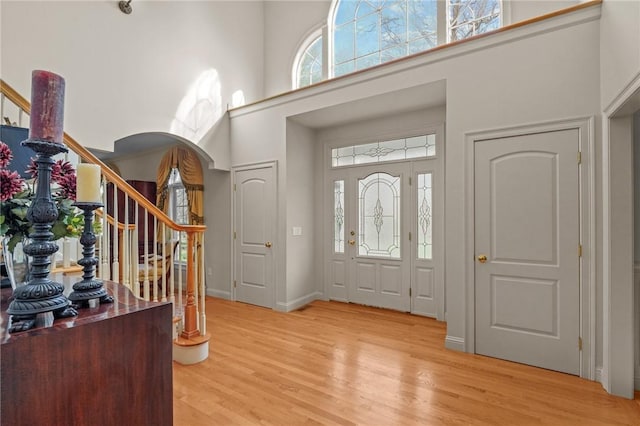 foyer featuring a healthy amount of sunlight, a high ceiling, and stairs