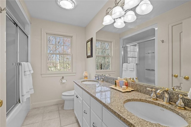 bathroom with an inviting chandelier, a sink, baseboards, and toilet