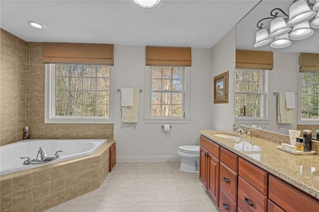 bathroom featuring a sink, double vanity, tile patterned floors, baseboards, and a bath