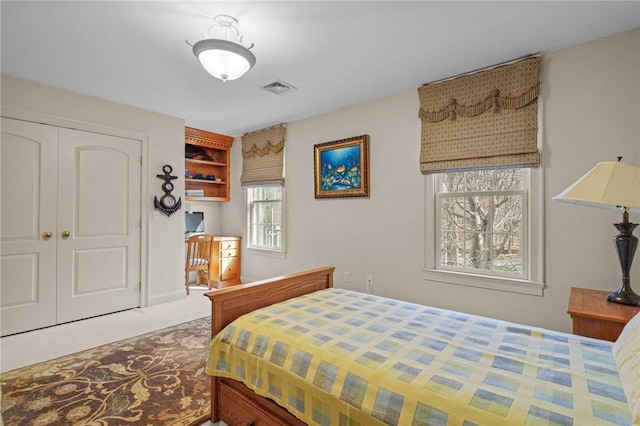bedroom featuring carpet floors, visible vents, and a closet