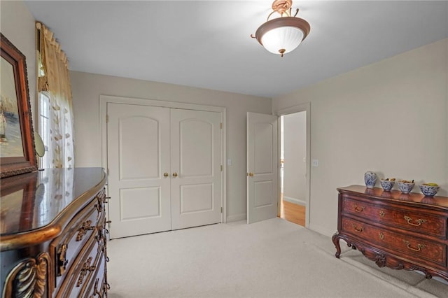 carpeted bedroom featuring baseboards and a closet