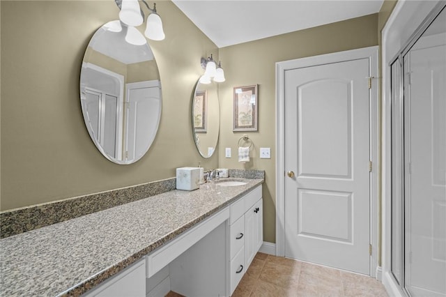 full bathroom featuring vanity, tile patterned flooring, a shower with shower door, and baseboards
