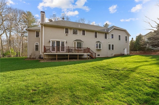 rear view of house featuring a lawn, a wooden deck, and a chimney