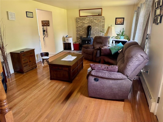 1 Gilman Rd, Hopkinton, RI 02832 - living room with a wood stove, a baseboard heating unit, light wood-style floors, and baseboards