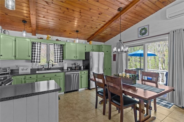kitchen with green cabinets, appliances with stainless steel finishes, a sink, dark countertops, and light tile patterned floors
