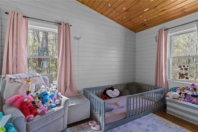 bedroom featuring wooden ceiling, lofted ceiling, wood finished floors, and wooden walls