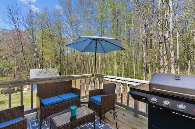 wooden deck featuring a forest view and area for grilling